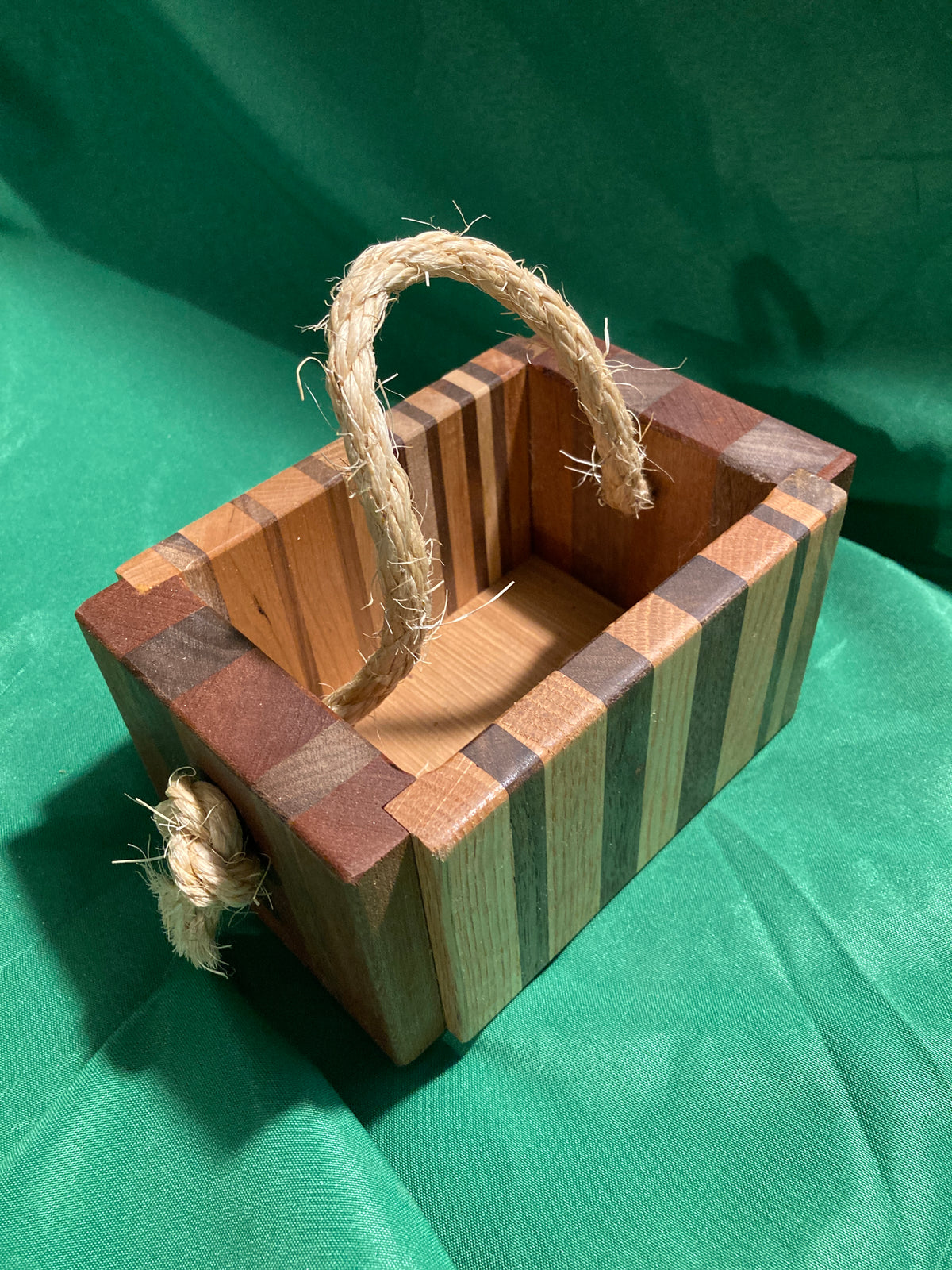 Small wood box with rope handle.