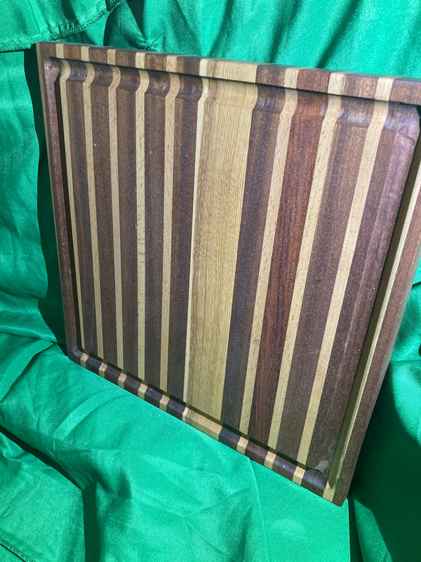 Large cutting board with juice groove. Handcrafted reclaimed wood. Jatoba wood. Hickory wood. Board with feet.