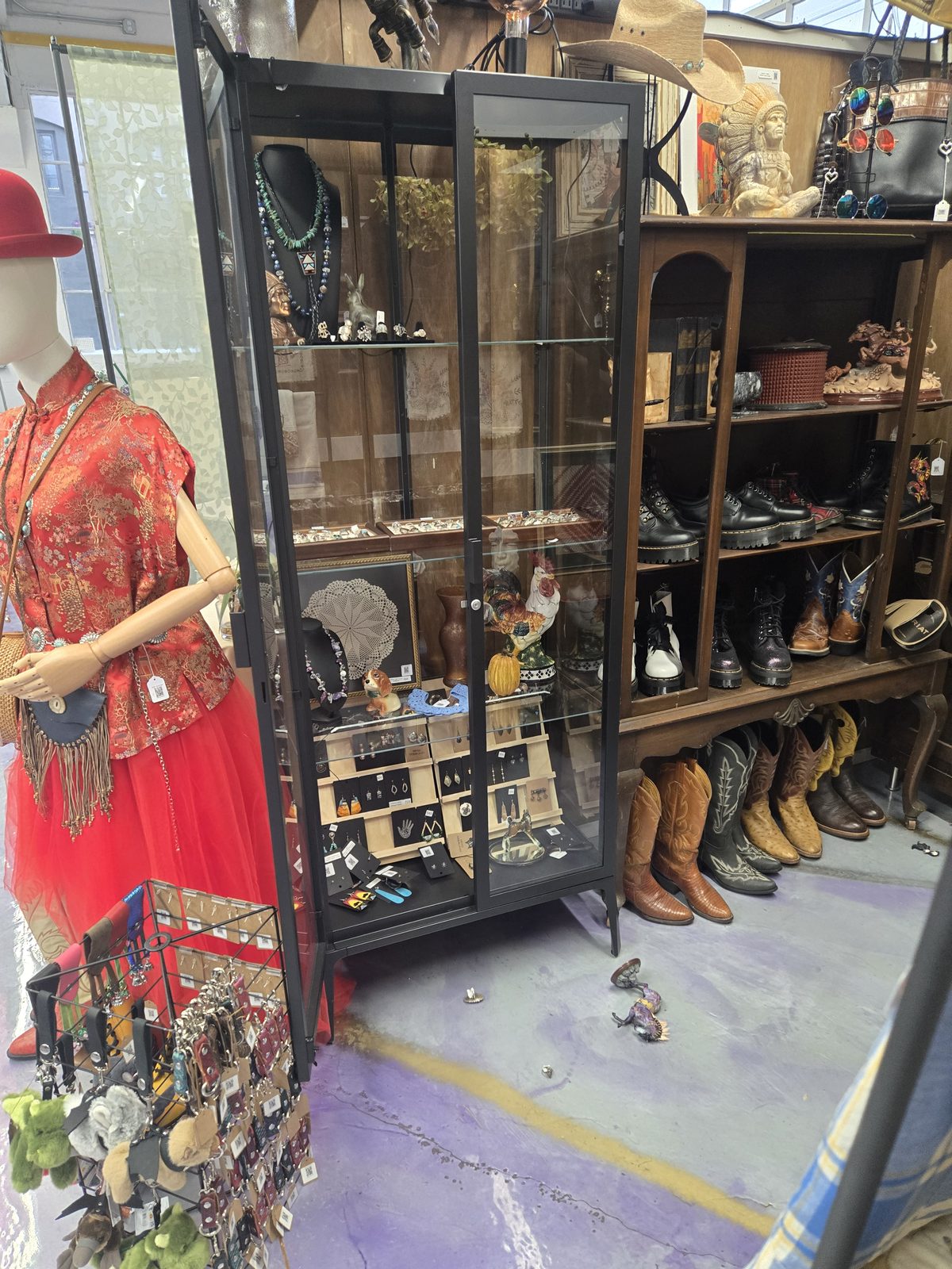 Vendor display cases filled with boots, jewelry, and collectibles at Lost & Found
