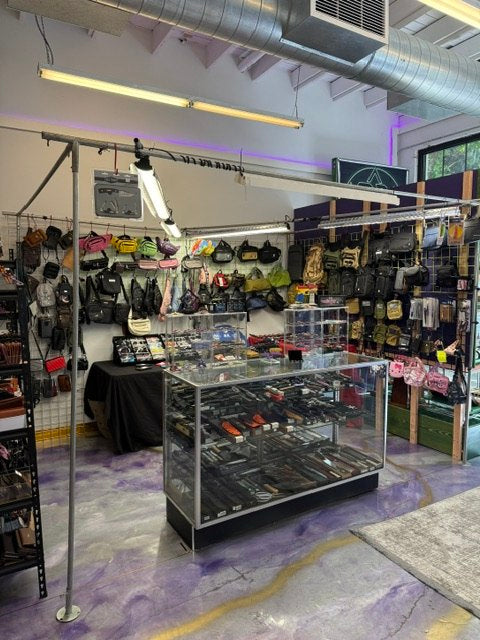 A vendor area with handbags, accessories, display cases, and shop lighting