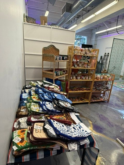 A vendor display with patterned textiles, folded goods, and wooden shelves
